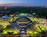 Wrocław Hala Stulecia nocą, z podświetloną fontanną i otaczającym parkiem.