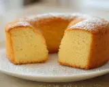 Un délicieux gâteau sans oeuf, saupoudré de sucre glace, est présenté sur une assiette blanche. Sa texture moelleuse est visible.