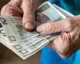 Dłonie seniora trzymają banknoty 10 zł. Kto może liczyć na 500 plus dla seniora?