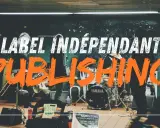 Un groupe de musique joue dans une station de métro. Le mot "PUBLISHING" en gros caractères orange suggère qu'il s'agit d'un label indépendant.