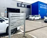 Znak kierunkowskazów w ASO wskazuje salon Peugeot, salon Citroën, serwis i centrum szkoleń.