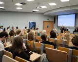 Wykład o specjalizacji BI, gdzie można zdobyć wiedzę potrzebną do zrobienia magisterki w rok. Studenci słuchają prezentacji.