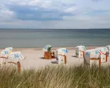 Plaża z koszami plażowymi, jakby to były luksusowe hotele w pałacach nad morzem.
