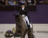 Kira Wulferding im Dressurstall, elegant in Frack und Zylinder, präsentiert ihr Pferd in einer anspruchsvollen Lektion.