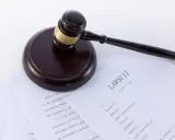 Młotek sędziowski na dokumentach sądowych, w tym na formularzu "LAWSUIT". Może posłużyć jako wzór wniosku o alimenty bez rozwodu.