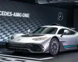 Silberner Mercedes-AMG ONE mit auffälligem Design und dem Schriftzug "MERCEDES-AMG ONE" im Hintergrund.