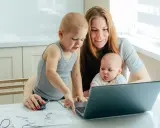 Mama z dwójką dzieci przy laptopie, starszak pokazuje coś na ekranie. To ich wspólny artystyczny projekt, może nawet z elementami art 188 kp.