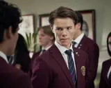 Ungdomar i skoluniformer, en av young royals skådespelare tittar intensivt.
