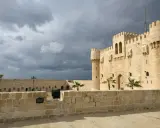 Die Zitadelle von Qaitbay in Aleksandria, Ägypten, ragt unter einem dramatischen Himmel auf.