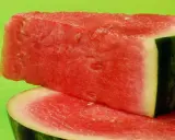 Saftige Wassermelonenstücke auf grünem Hintergrund. Perfekt für eine leichte Erfrischung, da Wassermelone kalorienarm ist.