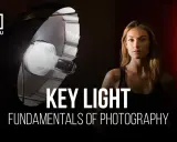 Modelo posa bajo luz de estudio, aprendiendo sobre iluminación clave. Fotos inspiradoras para fotógrafos.