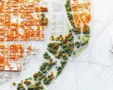 Model miasta z pomarańczowymi budynkami i zielonymi terenami. Widoczny plan ogólny z drogami i ścieżkami.