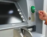 Mano insertando una tarjeta N26 extranjero en un cajero automático.