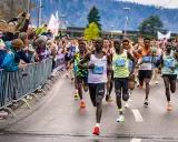 Läufer im Vordergrund einer Marathon-Geschichte, Zuschauer feuern sie an.