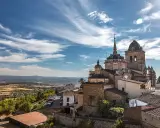 Blick auf die historische Stadt Jerez de los Caballeros mit ihren beeindruckenden Kirchtürmen unter einem dramatischen Himmel.