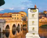 Guida digitale "Visit Rimini like a Local" con suggerimenti per colazione, passeggiate e cibo, sullo sfondo del Ponte di Tiberio.