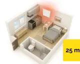 Jaki grzejnik elektryczny do pokoju 25m²? Wnętrze kawalerki z łóżkiem, aneksem kuchennym i łazienką, ogrzewane nowoczesnym panelem.