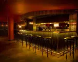 En elegant bar med gulddetaljer och barstolar, perfekt för en kväll på Rigoletto Stockholm.