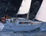 Trois personnes naviguent sur un voilier blanc, le "Pirat 26". Les voiles sont gonflées par le vent, créant une scène paisible.