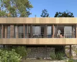 Casa moderna con fachada texturizada y grandes ventanales. Un hombre en el balcón. ¿Cuánto cuesta hacerse una casa teniendo el terreno?
