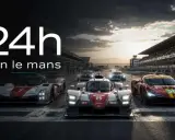 Le Mans Autos: Mehrere Rennwagen stehen bereit für das 24-Stunden-Rennen. Die Sonne geht unter und wirft lange Schatten auf die Rennstrecke.