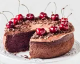 Gâteau chocolat cerise, riche et moelleux, décoré de cerises fraîches et de copeaux de chocolat. Un délice gourmand.