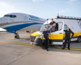 Trzech pracowników Enter Air stoi obok samolotu i vana. Chcesz wiedzieć, jak sprawdzić numer lotu Enter Air?