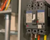 En industriell automatsäkring, redo att installera jordfelsbrytare. Kablar i orange, gult och grönt syns.