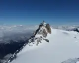 Szczyt Aiguille du Midi w Alpach Włoskich, z widokiem na morze chmur i ośnieżone góry.