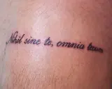 Tatuaż z łacińską sentencją "Nihil sine te, omnia tecum" na skórze.
