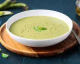 Una ciotola di cremoso purè di fave, guarnito con menta fresca e pepe nero, pronto per essere gustato.