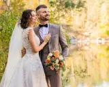 Młoda para w otoczeniu jesiennej przyrody. Ona w sukni ślubnej, on w garniturze. Trzymają bukiet. Zmieniła panieńskie nazwisko.