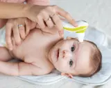 Mama mierzy temperaturę niemowlaka termometrem bezdotykowym.