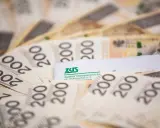 Polskie banknoty 200 zł i dokument ZUS. Ilustracja do przykładów przeliczenia emerytury kapitałowej na emeryturę powszechną.