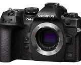 Czarny aparat OM SYSTEM OM-1 z obiektywem.