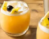 Zwei erfrischende Cocktails mit Zitronenzeste und Kirsche, perfekt für die Liste der 10 beliebtesten Cocktails.