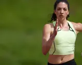 Eine Läuferin mit schweißglänzender Haut, die sich auf einem Laufband befindet und an ihre Grenzen geht. Sie trainiert hart für ihr nächstes Rennen, um ihre Leistung zu verbessern.