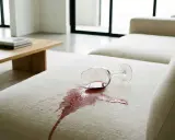 Ein umgekipptes Weinglas hinterlässt einen roten Fleck auf dem hellen Polster. So lassen sich Wasserflecken Polster entfernen.