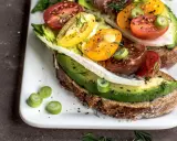 Herzhafte Avocado-Tomaten-Toasts auf Vollkornbrot, garniert mit Frühlingszwiebeln und Dill. Perfekt als kalorienarme Snacks für zwischendurch.