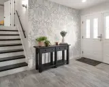 Hall med trappa och en konsol med växter. Vacker morris tapet inspiration med blommor och bladverk.