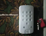 En Sector Alarm-panel med siffror och en SOS-knapp. Nycklar hänger bredvid. Ingen vill vara ett offer för bedragare.