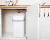 Un adoucisseur d'eau AEG blanc est installé sous un évier de cuisine. C'est une bonne idée de savoir quand installer un adoucisseur d'eau pour une eau plus douce.