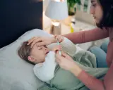 Mutter misst Fieber bei krankem Kind. Hoffnung auf Heilung, auch bei Kinder Asthma.