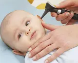 Esame dell'orecchio di un neonato per diagnosticare un'otite.