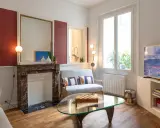 Plan salon 16m2 : cheminée en marbre, canapé gris, table basse en verre avec jeu d'échecs, fenêtre lumineuse.