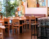 Mysig restaurang med många växter. Bord och stolar i trä. Belysning skapar en varm atmosfär. Bra ställe för bise recensioner.