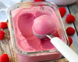 Glace framboise sans sorbetière, on dirait qu'elle est faite avec du lait concentré. Une boule est prélevée avec une cuillère.