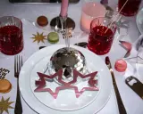 Enkel nyårsdukning med disco-boll, stjärnor, macarons och röda drinkar. En festlig och glittrig bordsdekoration för att fira in det nya året.