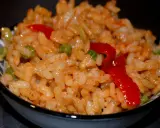 Un bol de riz coloré avec des petits pois et des poivrons rouges, parfait pour une recette salade riz facile et rapide.