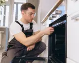 Un technicien vérifie la hauteur et l'étanchéité d'un four encastrable.